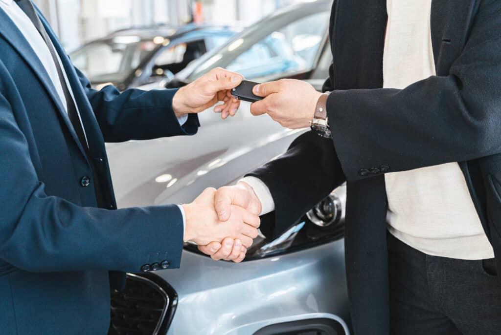 Schlüsselübergabe nach Neuwagenkauf im Autohaus